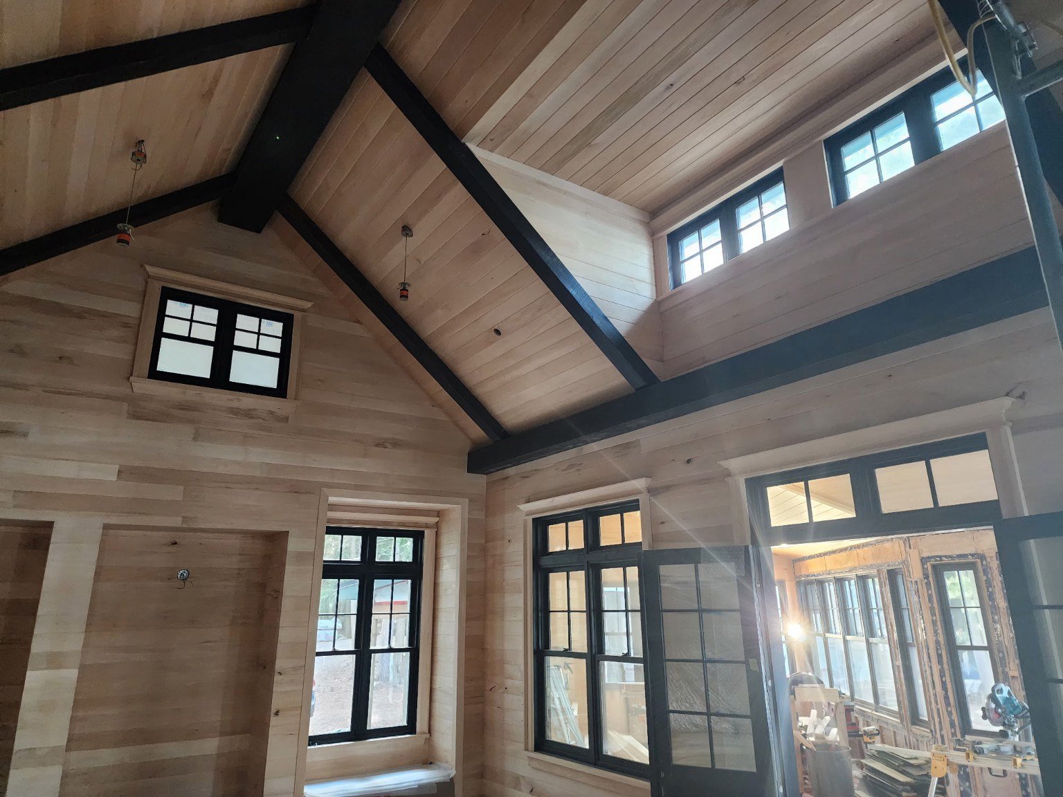 Tongue and groove walls and ceiling with dark beams in a custom home under construction