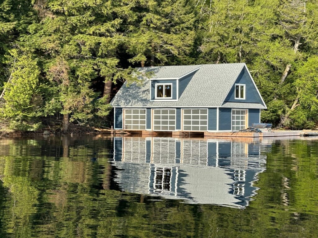 Blue waterfront building with contrasting exterior trim reflected in the lake